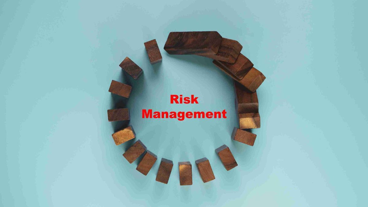 A circular arrangement of wooden dominoes with the phrase risk management positioned at the center