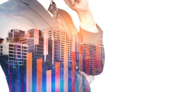 A double exposure image of a businessman in a suit with a transparent overlay of city skyscrapers.