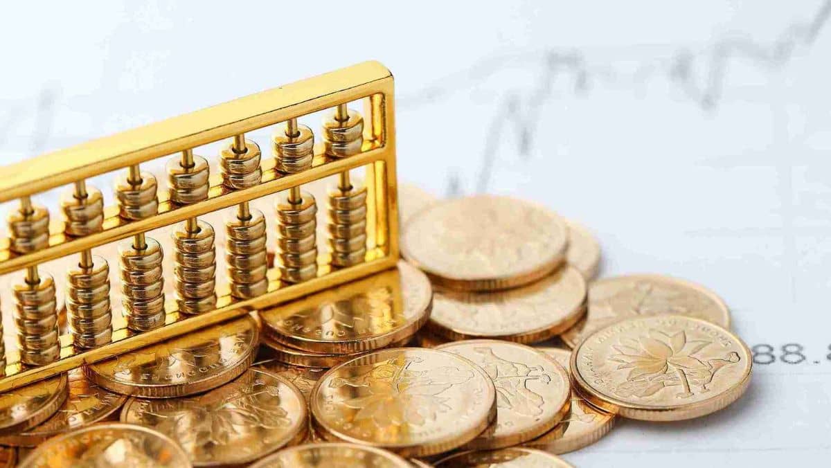 A golden abacus surrounded by scattered coins, with a line graph positioned below