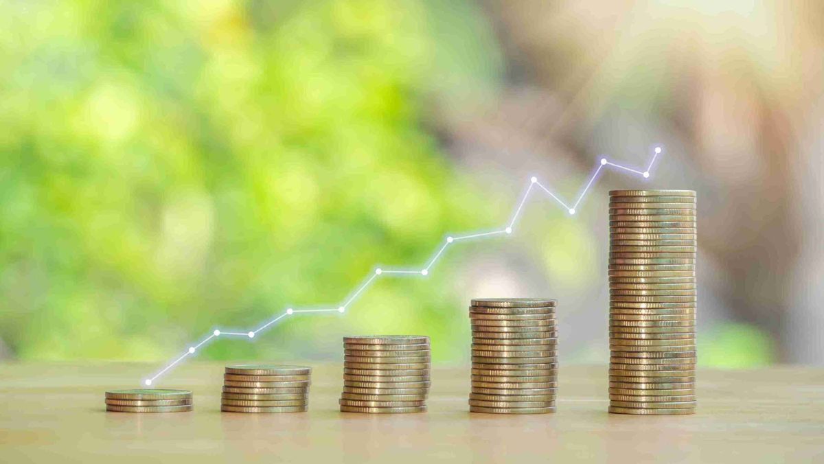 A line graph sits atop a stack of gold coins arranged in ascending order