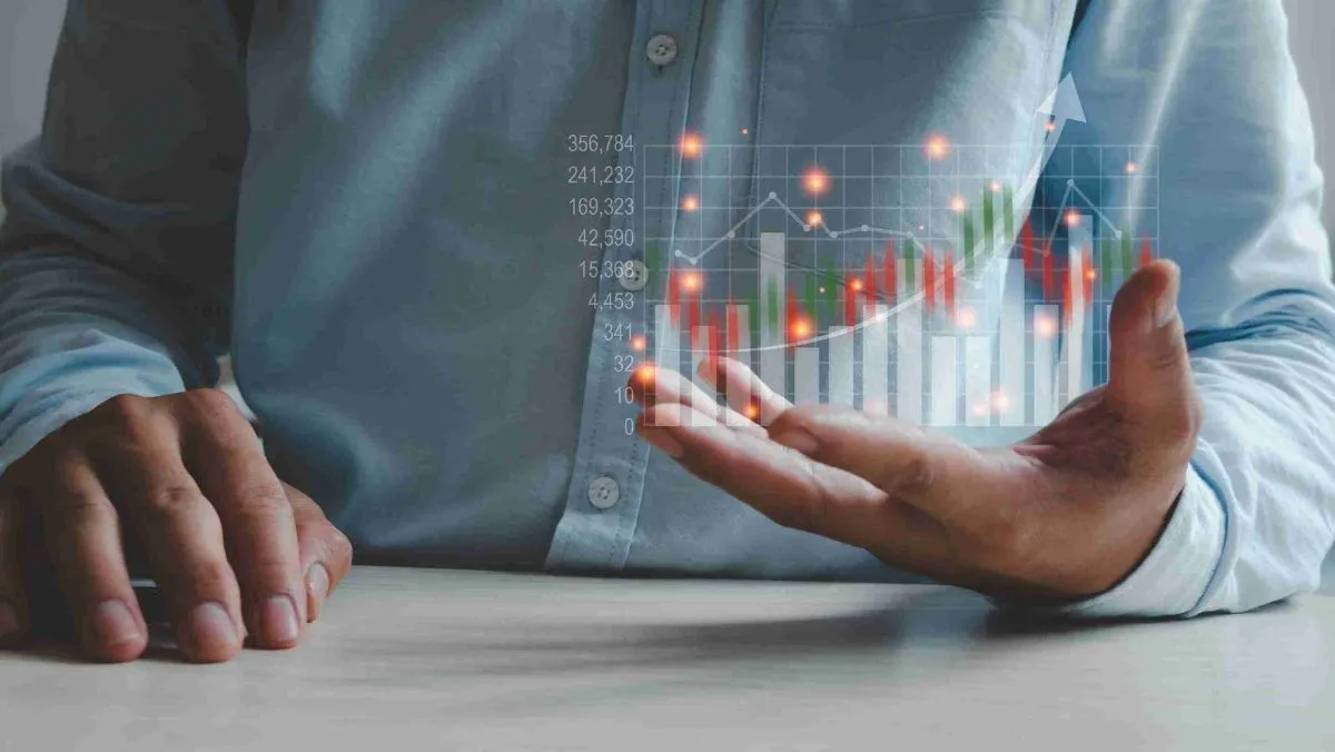 A man sitting firmly with a hologram of a trading chart at his left hand