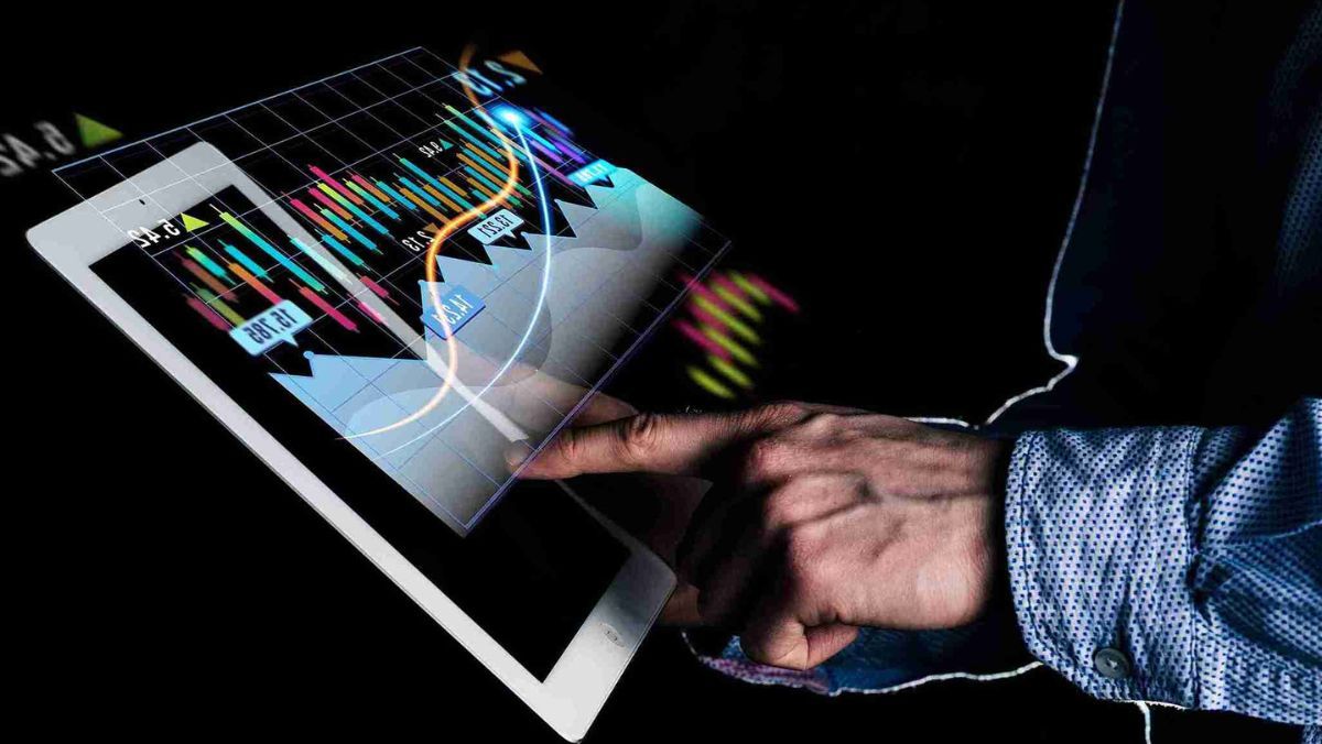 A person engaged in trading activities on a tablet against a dark background