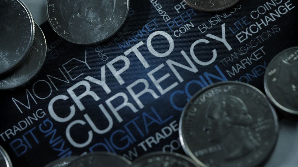 Assorted coins with cryptocurrency symbols on a digital background with financial terms highlighting crypto trading
