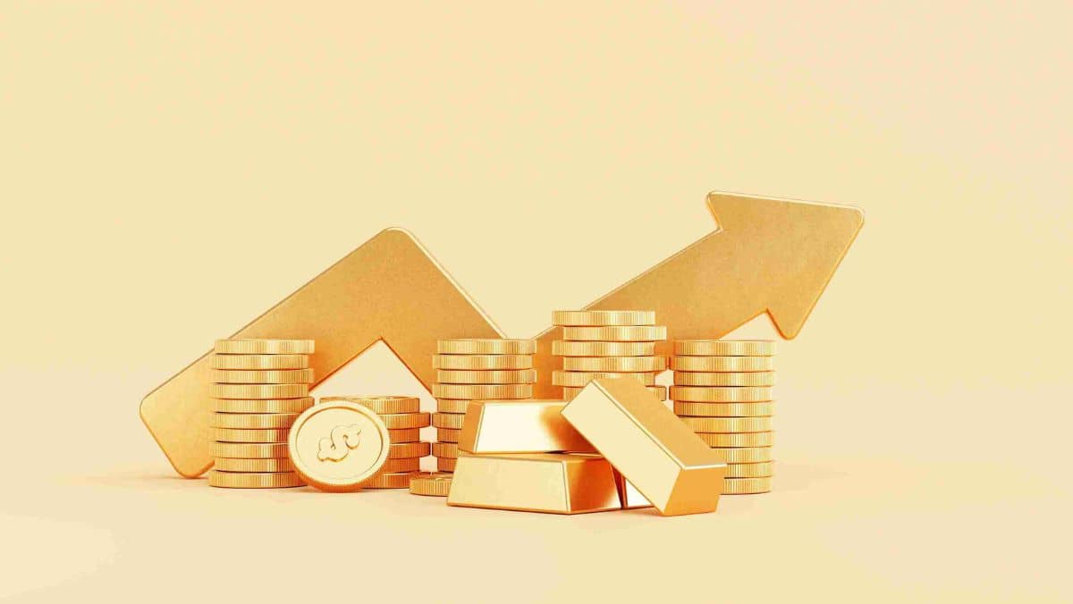Gold bars and coins arranged alongside an arrow indicating an upward trajectory