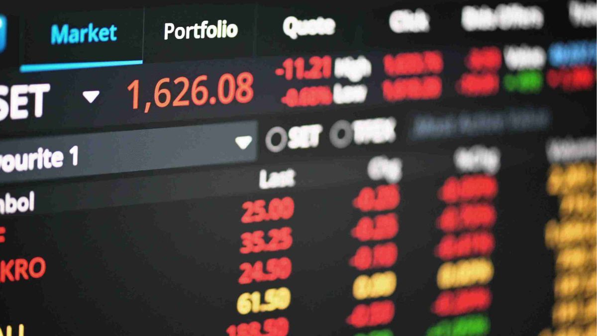 Stock market information displayed on a digital screen featuring numbers in red green and yellow hues