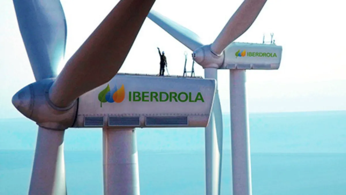 Two IBERDROLA-branded wind turbines, one featuring a person standing on top
