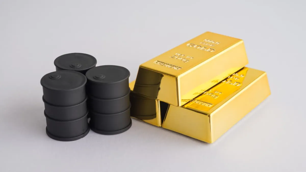 a few barrels of oil next to a pile of gold bars