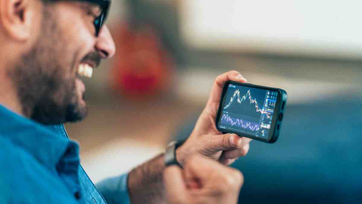 a person is smiling while social trading on a phone and looking at the screen