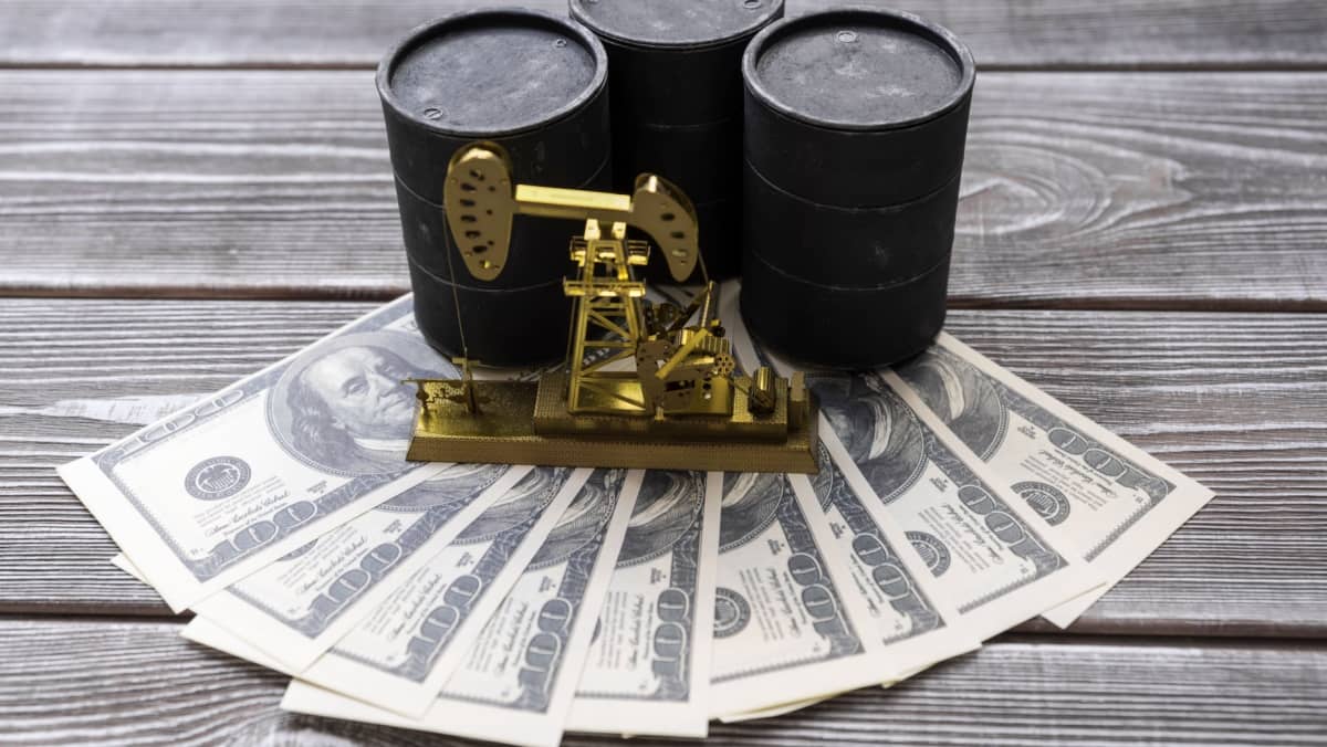 three barrels of oil, neftechka, and American dollars against the background of a wooden table